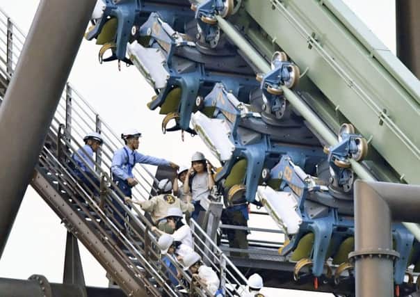 Passengers rescued from the stopped Flying Dinosaur rollercoaster at Universal Studios Japan. Picture: AP
