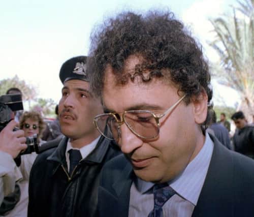 Abdel Basset Ali al-Megrahi, right, is escorted by a police officer to court in Tripoli, Libya, in 1992. Picture: Jockel Fink