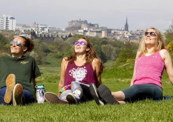 Sun worshippers enjoy the Bank Holiday Monday in Holyrood Park, Edinburgh with Edinburgh Castle in the distance. Picture: SWNS