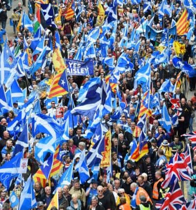 Anti-independence supporters wave Union Jack flags (R) as thousands of demonstrators carry Saltire flags, the national flag of Scotland.