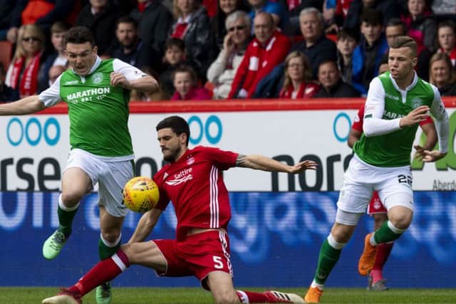 Anthony OConnor earns an early booking as his trip on John McGinn prevents the Hibs midfielder from breaking clear. Picture: SNS.