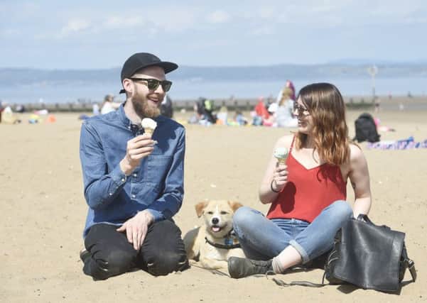 David Bowes and Beth Stanners enjoy and ice cream on Portobello beach in the sunshine with Buffy the dog. Picture: Greg Macvean