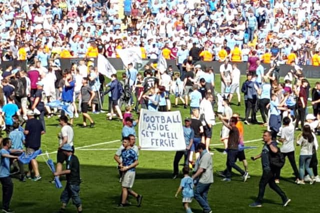 Manchester City fans hold up a sign reading "Football Aside Get Well Soon Fergie" in reference to former Manchester United manager Sir Alex Ferguson. Picture: PA Wire