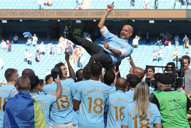 Manchester City players hoist manager Pep Guardiola as they celebrate their title triumph. Picture: PA