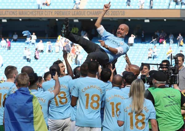 Manchester City players hoist manager Pep Guardiola as they celebrate their title triumph. Picture: PA