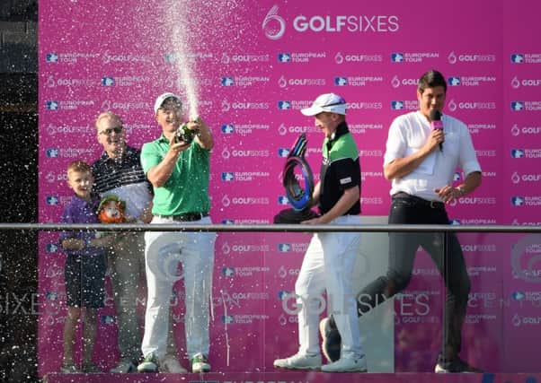 Gavin Moynihan, centre, holds the trophy as his team-mate Paul Dunne sprays champagne and sends host Vernon Kay scurrying. Picture: Getty.
