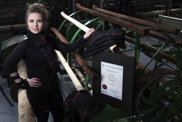 Clare Campbell, founder of textile design house Prickly Thistle, with the Runrig tartan. PIC: Contributed.
