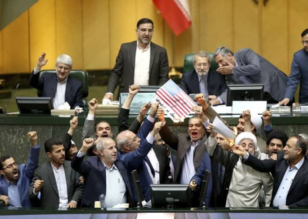 Iranian politicians burn two pieces of papers representing the US flag. Picture: AP