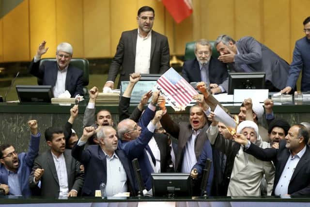 Iranian politicians burn two pieces of papers representing the US flag. Picture: AP