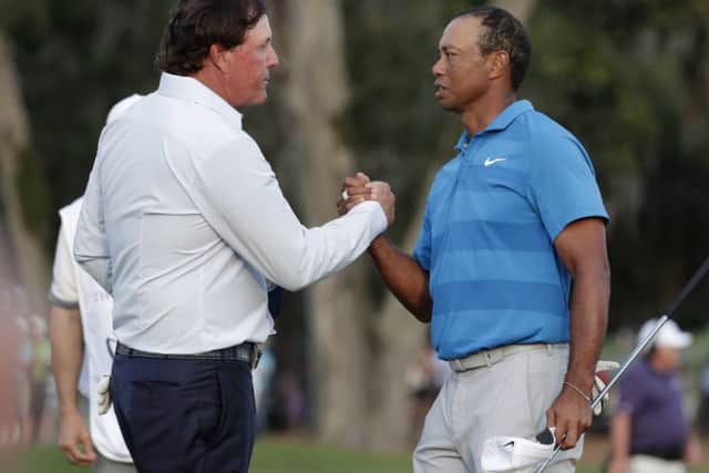 Phil Mickelson, left, and Tiger Woods shake hands after carding 79 and 72 respectively in the opening round at TPC Sawgrass in Florida. Picture: AP