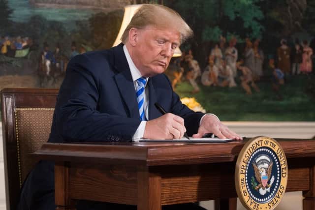 US President Donald Trump signs a document reinstating sanctions against Iran after announcing the US withdrawal from the Iran Nuclear deal. Picture: (AFP/Getty Images)
