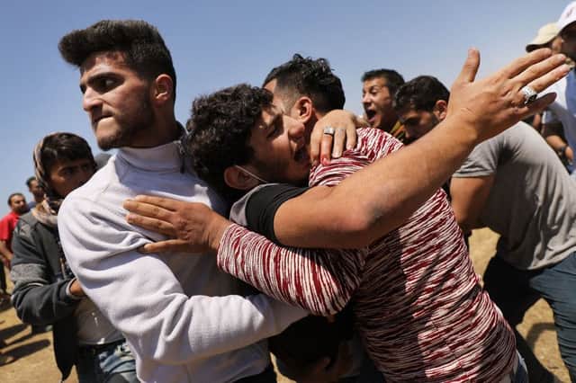 A wounded Palestinian man is rushed to an ambulance at the border fence with Israel as mass demonstrations continue in Gaza. Picture: Spencer Platt/Getty Images)