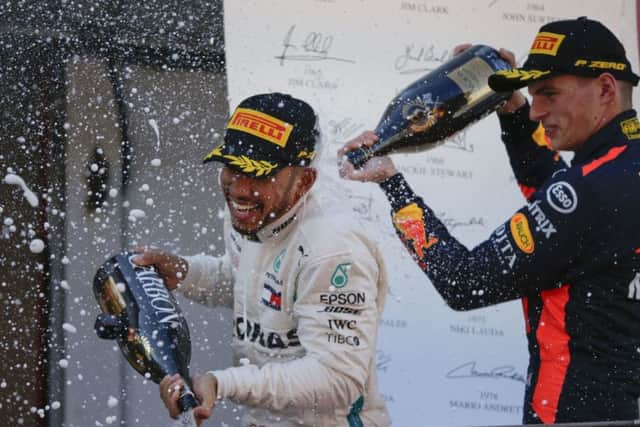 Winner Mercedes driver Lewis Hamilton of Britain sprays champagne, left, flanked by third place Red Bull driver Max Verstappen of the Netherlands, on the podium after the Spanish Formula One Grand Prix at the Barcelona Catalunya racetrack in Montmelo, Spain, Sunday, May 13, 2018. (AP Photo/Emilio Morenatti)