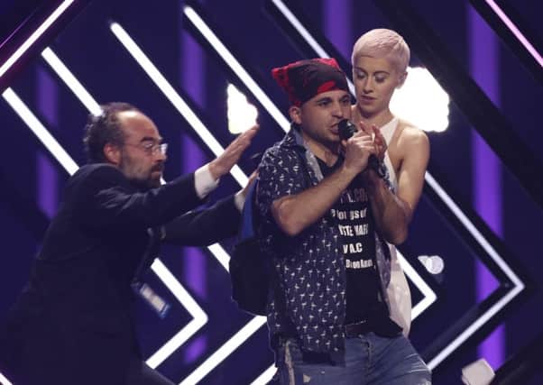 The man grabbed the microphone from the UK's SuRie during her performance. Picture: AP Photo/Armando Franca