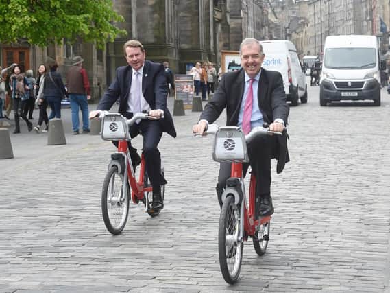 Angus Cockburn of Serco and George Lowder of Transport for Edinburgh trying out the new bikes on the Royal Mile. Picture: Greg Macvean