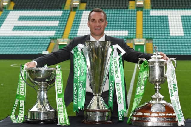 Celtic manager Brendan Rodgers celebrates with this season's trio of trophies. Picture: SNS/Paul Devlin
