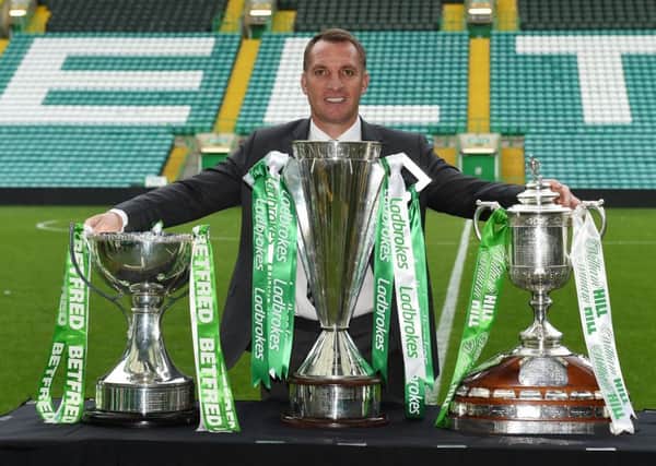Celtic manager Brendan Rodgers celebrates with this season's trio of trophies. Picture: SNS/Paul Devlin