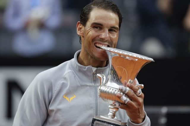 Rafael Nadal adopts his customary winning pose by biting the trophy following his 6-1, 1-6, 6-3 victory of Alexander Zverev. Picture: AP.