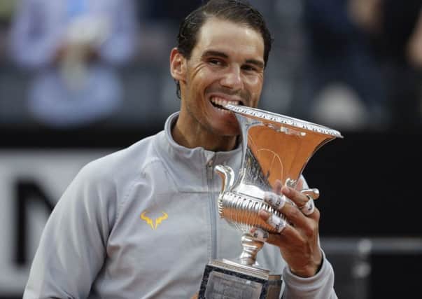 Rafael Nadal adopts his customary winning pose by biting the trophy following his 6-1, 1-6, 6-3 victory of Alexander Zverev. Picture: AP.