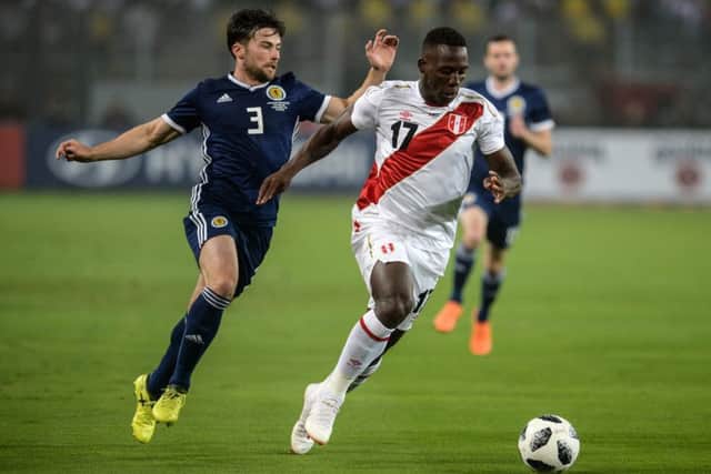 Lewis Stevenson, one of seven debutants, vies for the ball with Peru's Luis Advincula. Picture: Ernesto Benavides/AFP/Getty Images