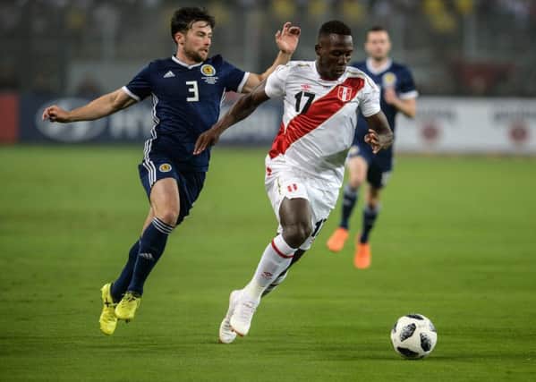 Lewis Stevenson, one of seven debutants, vies for the ball with Peru's Luis Advincula. Picture: Ernesto Benavides/AFP/Getty Images