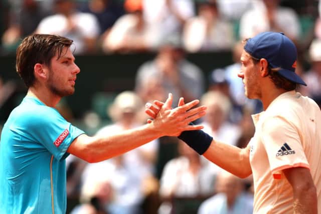 Cameron Norrie, left, congratulates Lucas Pouille of France on his victory at Roland Garros. Picture: Clive Brunskill/Getty