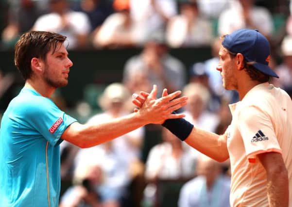 Cameron Norrie, left, congratulates Lucas Pouille of France on his victory at Roland Garros. Picture: Clive Brunskill/Getty