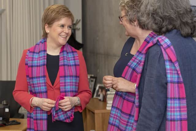 First Minister Nicola Sturgeon is presented with a Friends of Cancer Research UK tartan scarf by Elaine Monro, the Selkirk based Cancer Research UK fundraising committee member who came up with the idea for the tartan