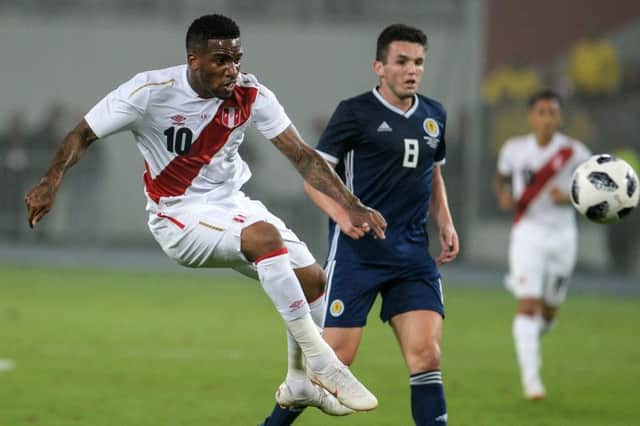 John McGinn, right, was one of three Hibs players to feature against Peru. Picture: AFP