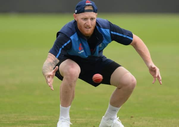 Ben Stokes, with strapping on his hamstring, bends down to catch a ball in training. Picture: Getty.