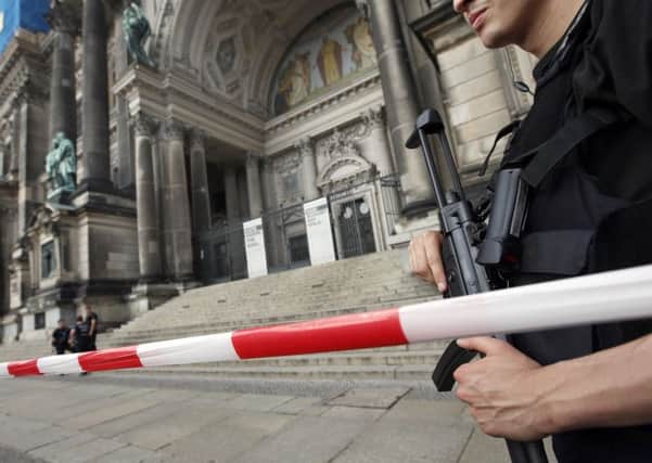 A police officer with a gun stands in front of the Berlin Cathedral (AP Photo/Michael Sohn)