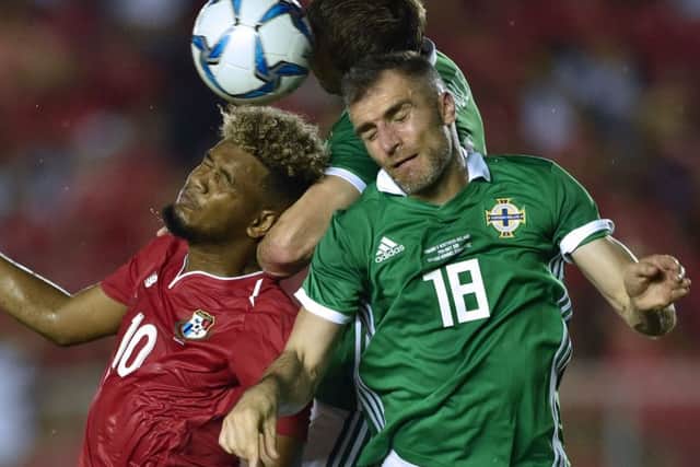 Aaron Hughes, right, is still undecided about whether to carry on playing. Picture: AFP/Getty.
