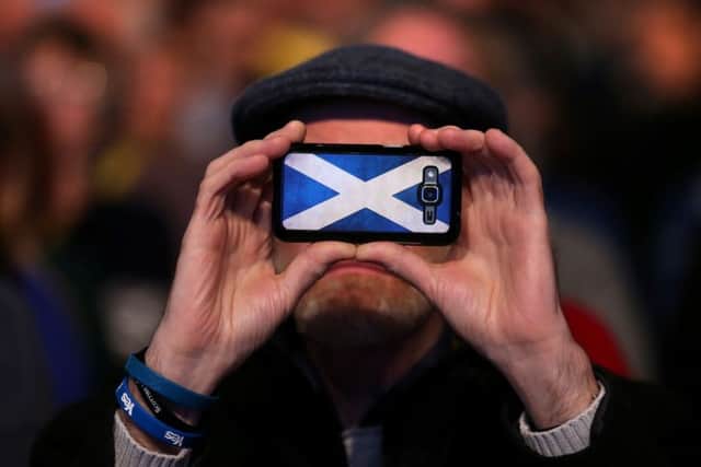 An SNP supporter takes a picture at the SNP spring conference at the SECC in Glasgow.