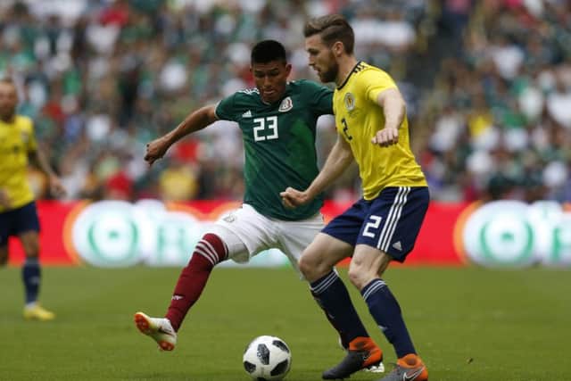 Scotland right-back Stephen ODonnell battles with Mexicos Jesus Gallardo at Estadio Azteca. Picture: AP.