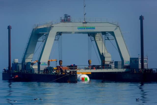 The data centre is partially submerged and cradled by winches and cranes between the pontoons of an industrial catamaran-like gantry barge. Picture: Scott Eklund/Red Box Pictures