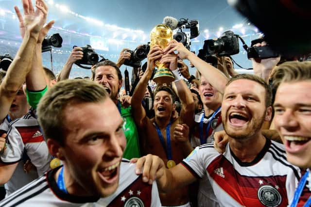 Mesut Ozil raises the World Cup with his Germany team-mate. Photograph: Matthias Hangst/Getty Images