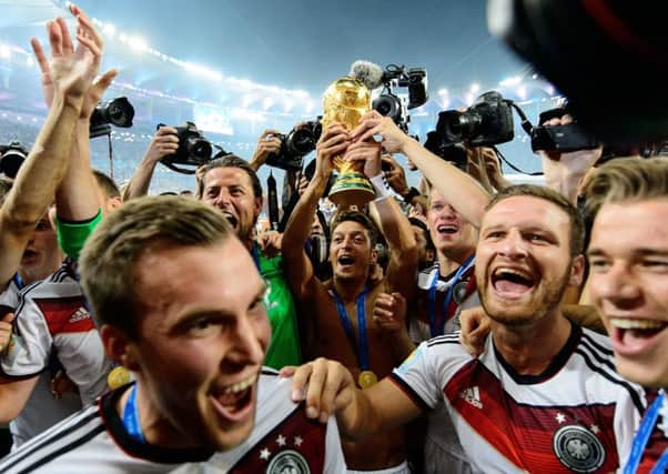 Mesut Ozil raises the World Cup with his Germany team-mate. Photograph: Matthias Hangst/Getty Images