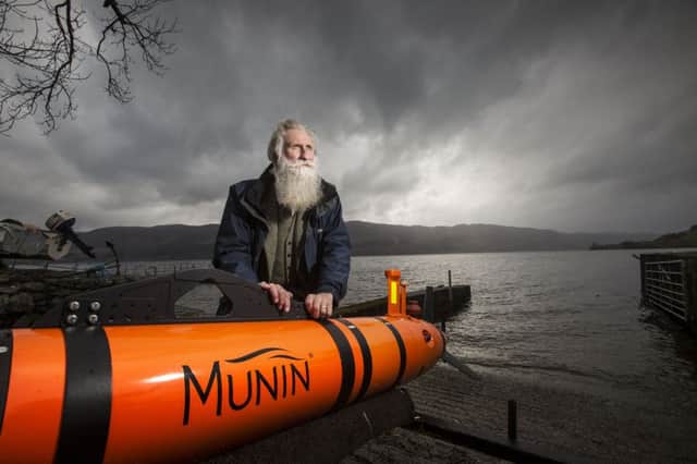 Adrian Shine of the Loch Ness project poses with the Munin vehicle on Loch Ness