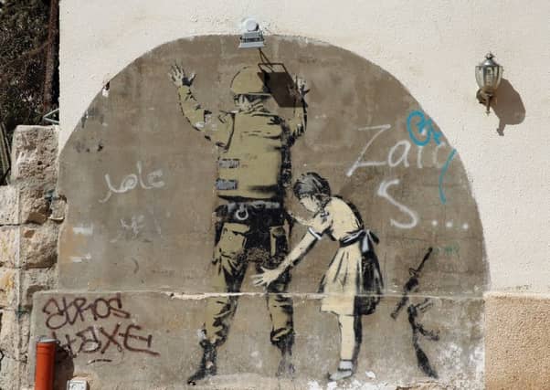 A Banksy mural on a security wall near Bethlehem in central West Bank. (Picture: Getty)