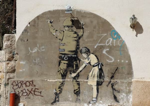 A Banksy mural on a security wall near Bethlehem in central West Bank.  (Picture: Getty)