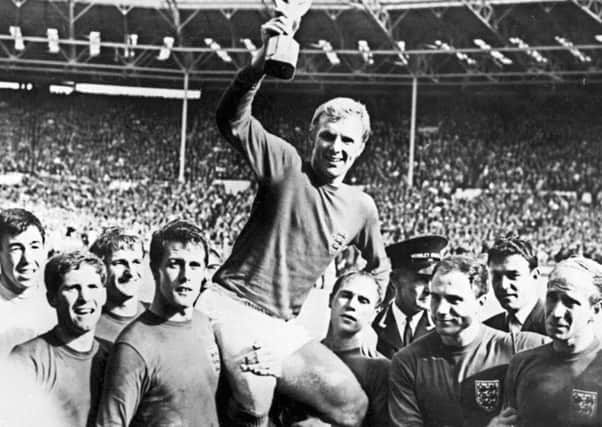 Ray Wilson, right, and Geoff Hurst carry England captain Bobby Moore in triumph after winning the World Cup at Wembley. Picture: AFP