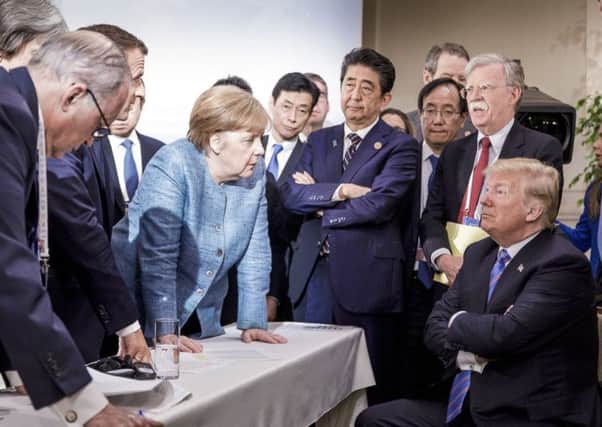 Angela Merkel looks like she is giving Donald Trump a row while the US President exudes a toddler-like defiance. Picture: AP