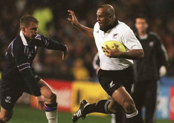 AUCKLAND, NEW ZEALAND - JULY 02:  All Black Jonah Lomu prepares to fend off Scotland's Cameron Murray in the second test at Eden Park, Auckland, Saturday. New Zealand won 4814.  (Photo by Ross Setford/Getty Images)