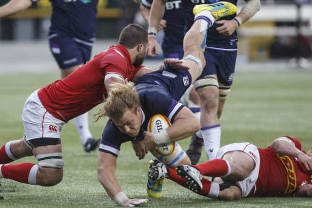 Scotland's David Denton is tackled by Canada's Luke Campbell and Nick Blevins. Picture: AP