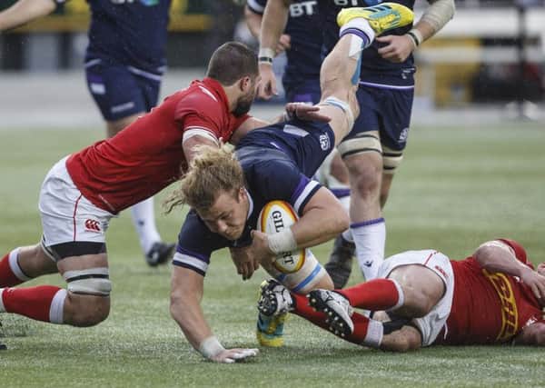 Scotland's David Denton is tackled by Canada's Luke Campbell and Nick Blevins. Picture: AP