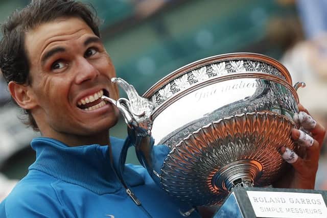 Rafael Nadal bites the trophy after winning his 11th French Open title. Picture: AP.