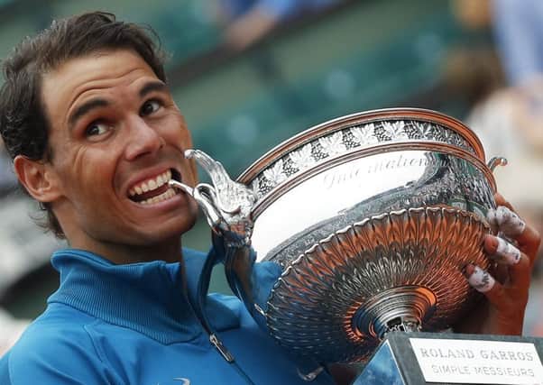 Rafael Nadal bites the trophy after winning his 11th French Open title. Picture: AP.