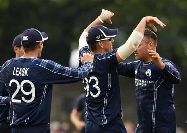 Scotland players celebrate taking the wicket of Moeen Ali during the victory at the Grange. Picture: SNS.