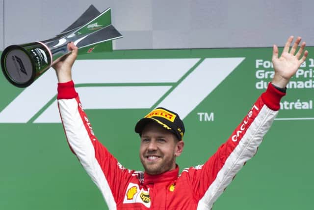 Sebastian Vettel raises his winners trophy after flying to victory at the Canadian Grand Prix in Edmonton yesterday. Picture: AP
