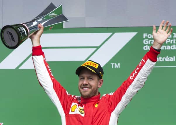 Sebastian Vettel raises his winners trophy after flying to victory at the Canadian Grand Prix in Edmonton yesterday. Picture: AP